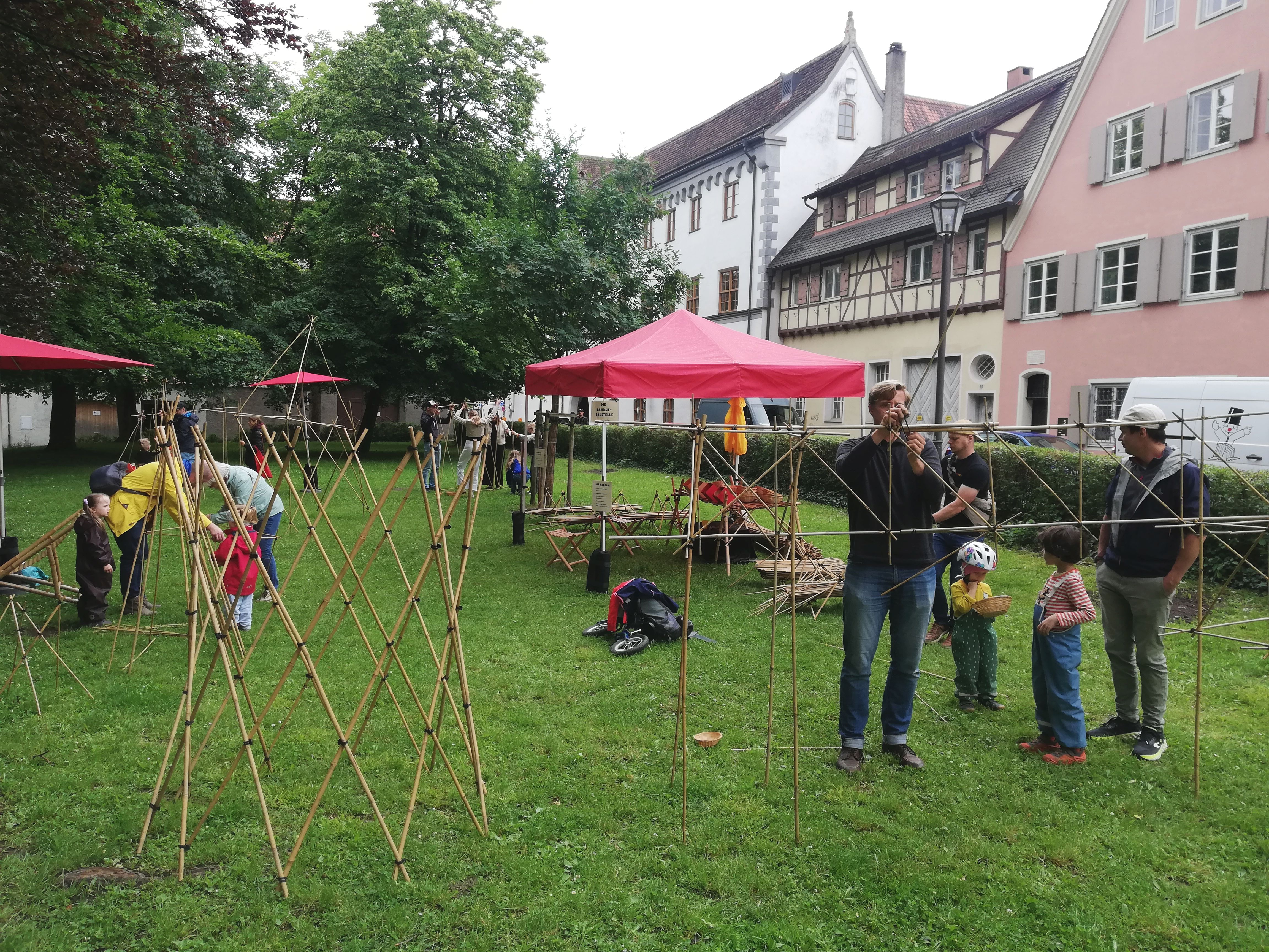 Kinder und Eltern bauen mit Bambusstäben auf dem Stadtfest in Memmingen